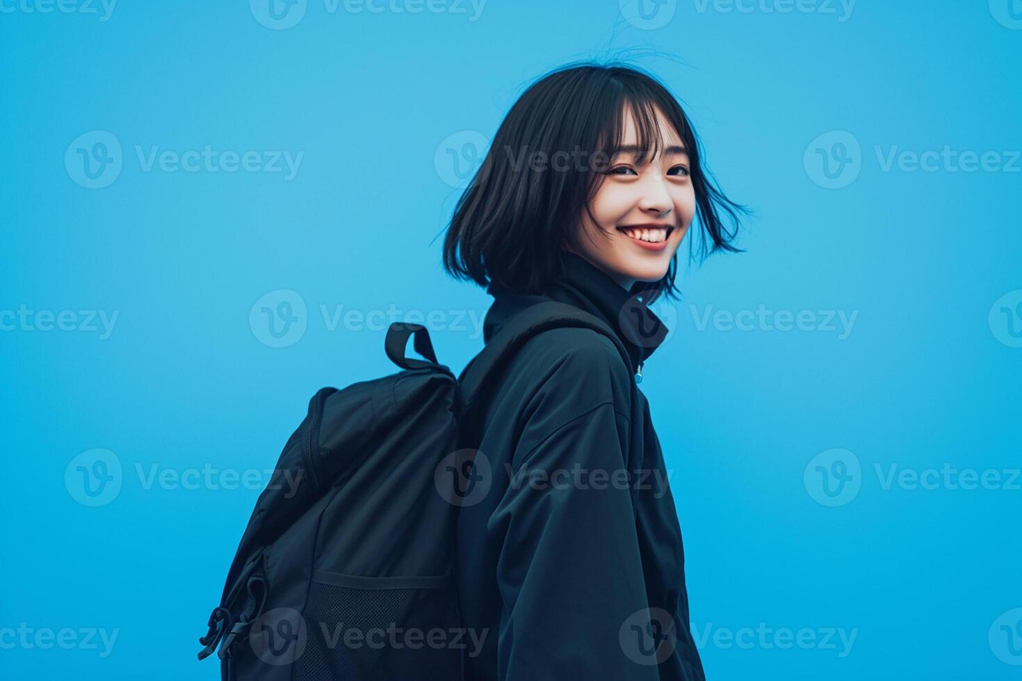 A young woman with a backpack on a blue background photo