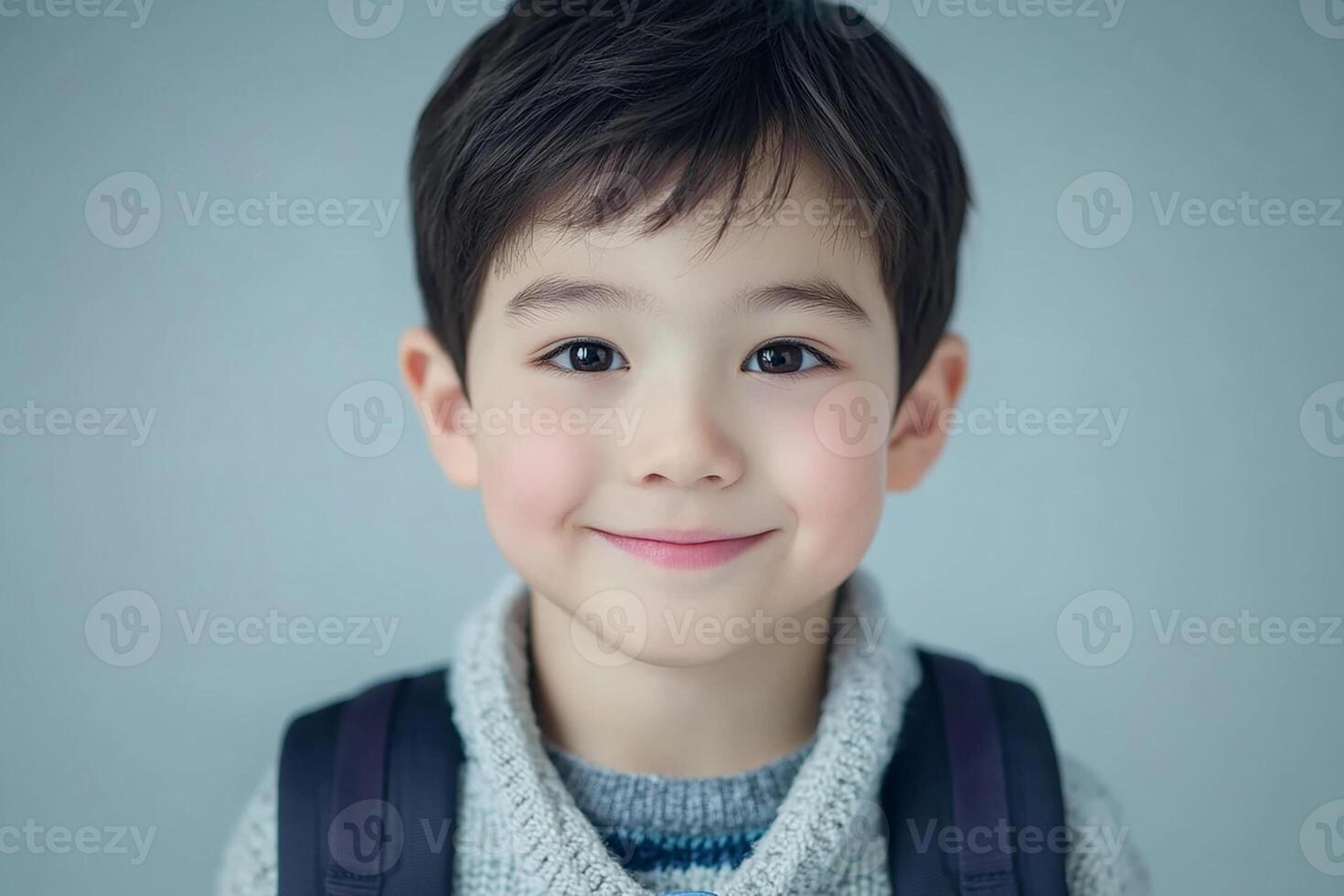 A young boy with a backpack smiling photo