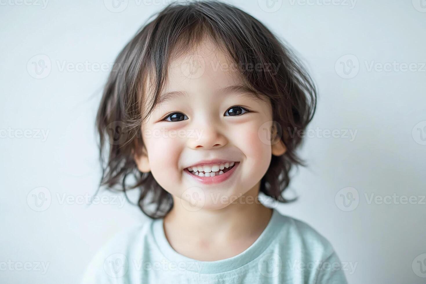 A young child is smiling and looking at the camera photo