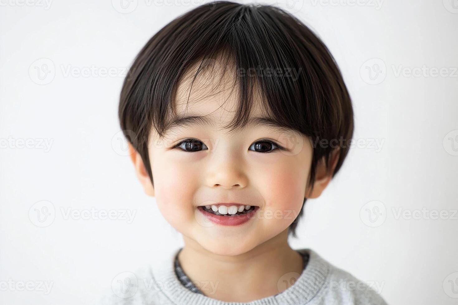 A little boy with black hair smiling photo