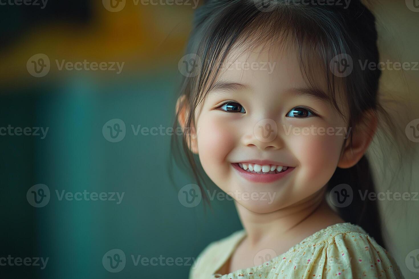 A little girl is smiling and looking at the camera photo