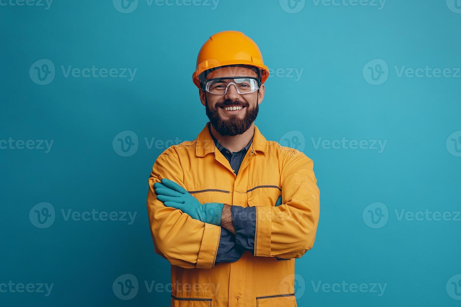 Portrait of a smiling man in yellow workwear standing on a blue background photo