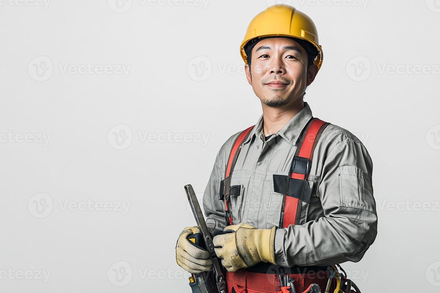 Asian male construction worker holding a tool photo