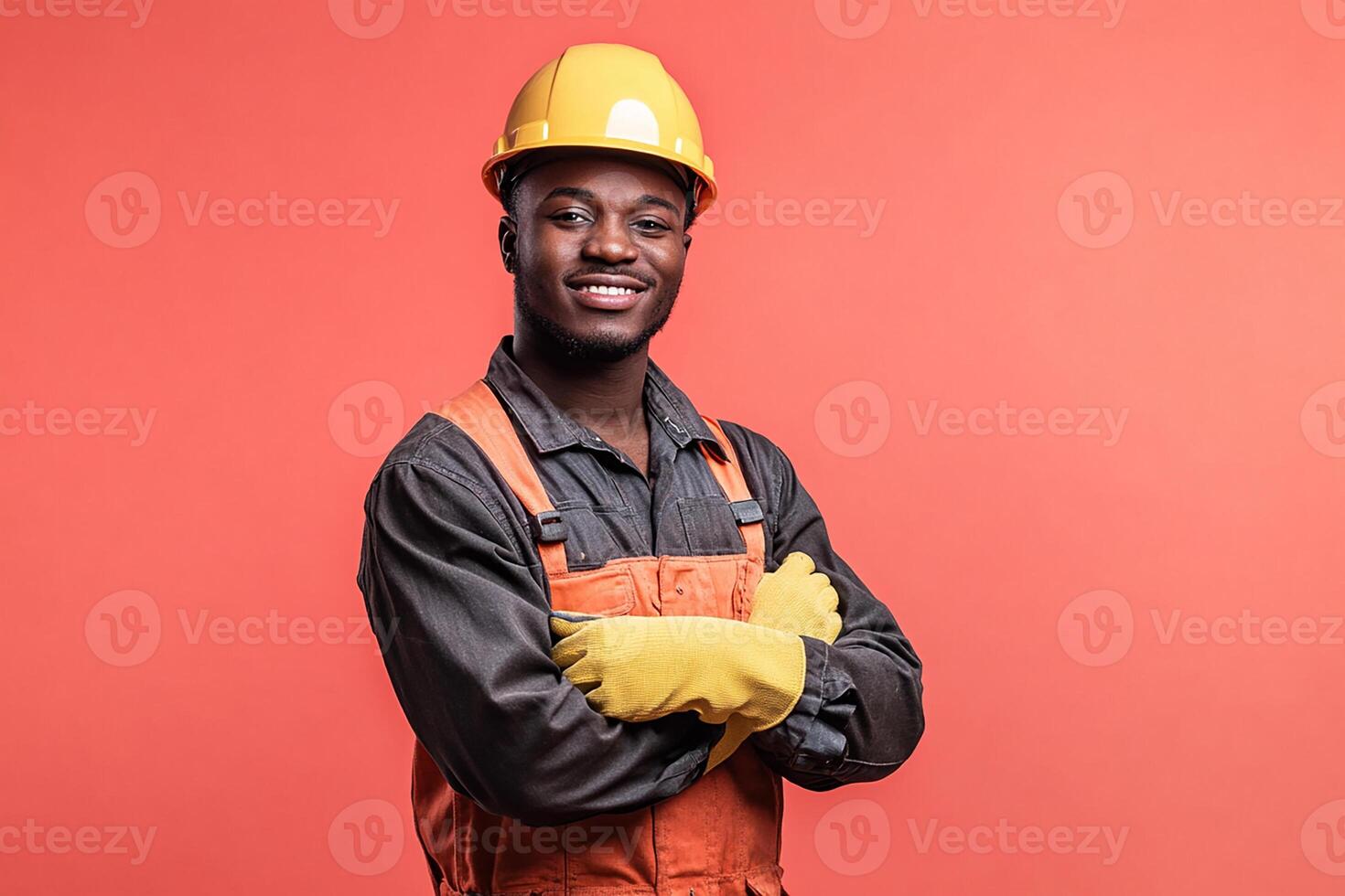 An african american man in an orange hard hat and overalls photo