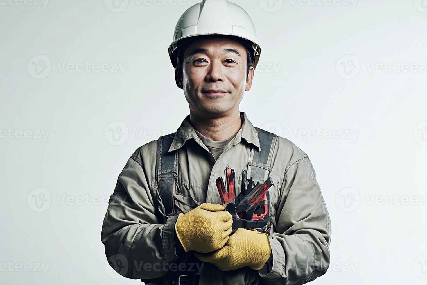 A man in a hard hat and gloves holding a pair of gloves photo