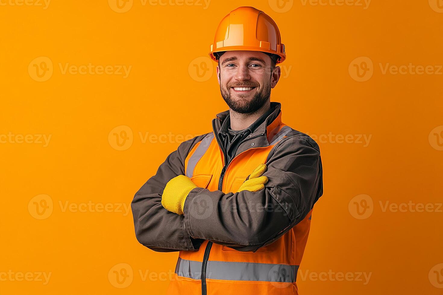 Portrait of smiling male construction worker isolated on orange background photo