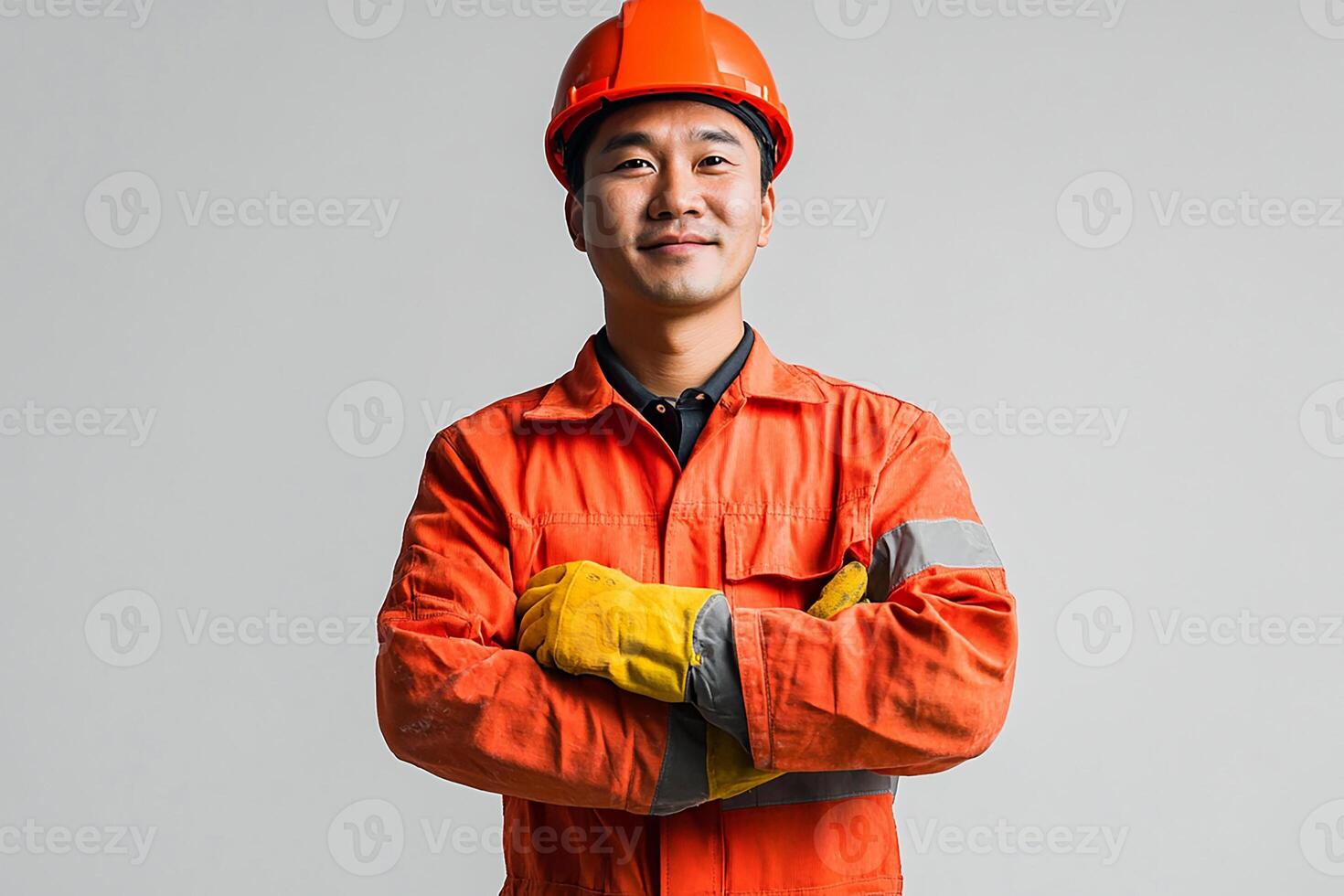 Asian man in orange workwear standing with arms crossed photo