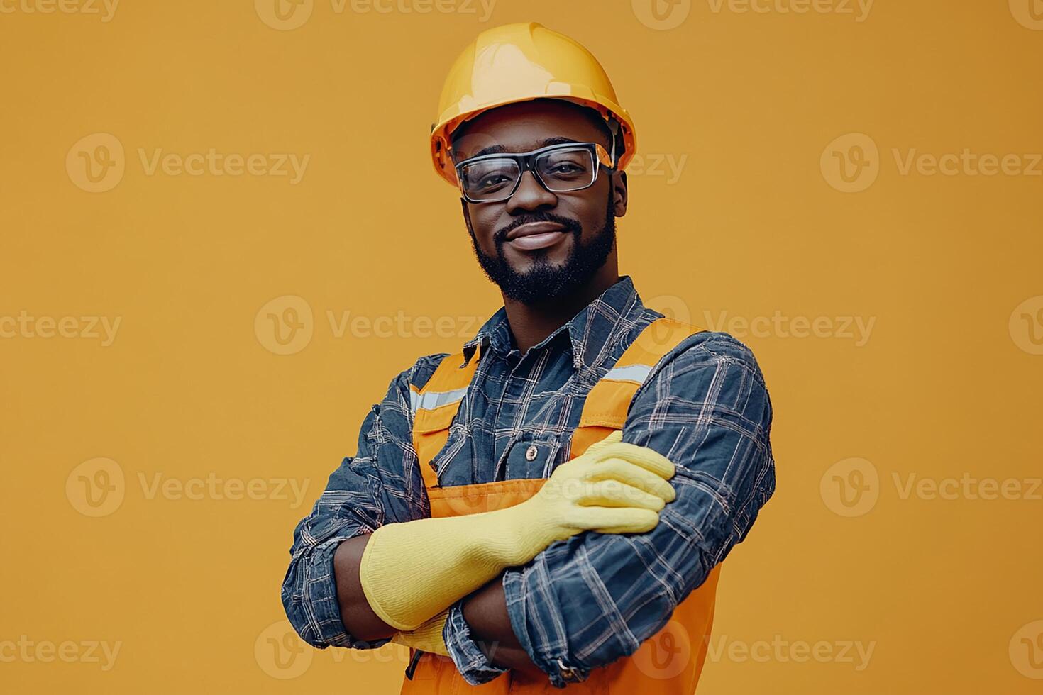 A black man in an orange hard hat and safety glasses photo