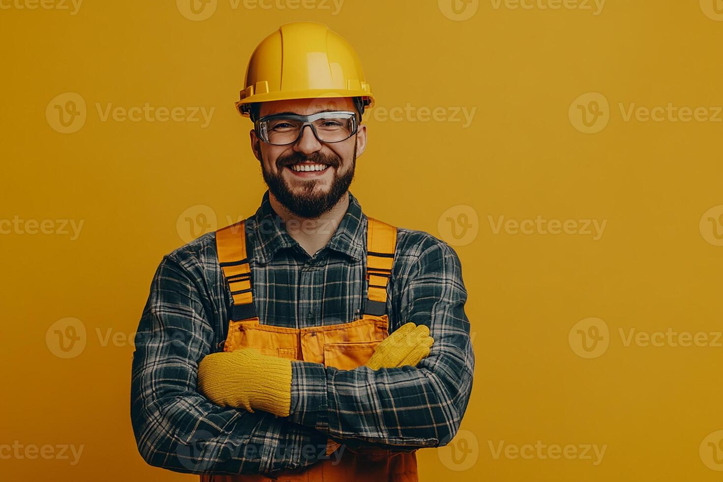 Portrait of a smiling man in overalls standing on yellow background photo