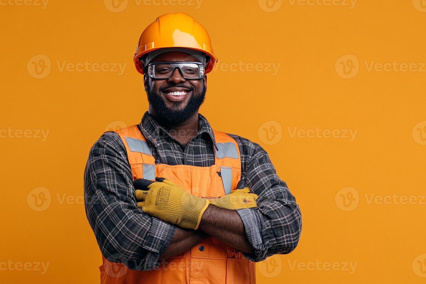 An african american man in an orange hard hat and safety glasses photo