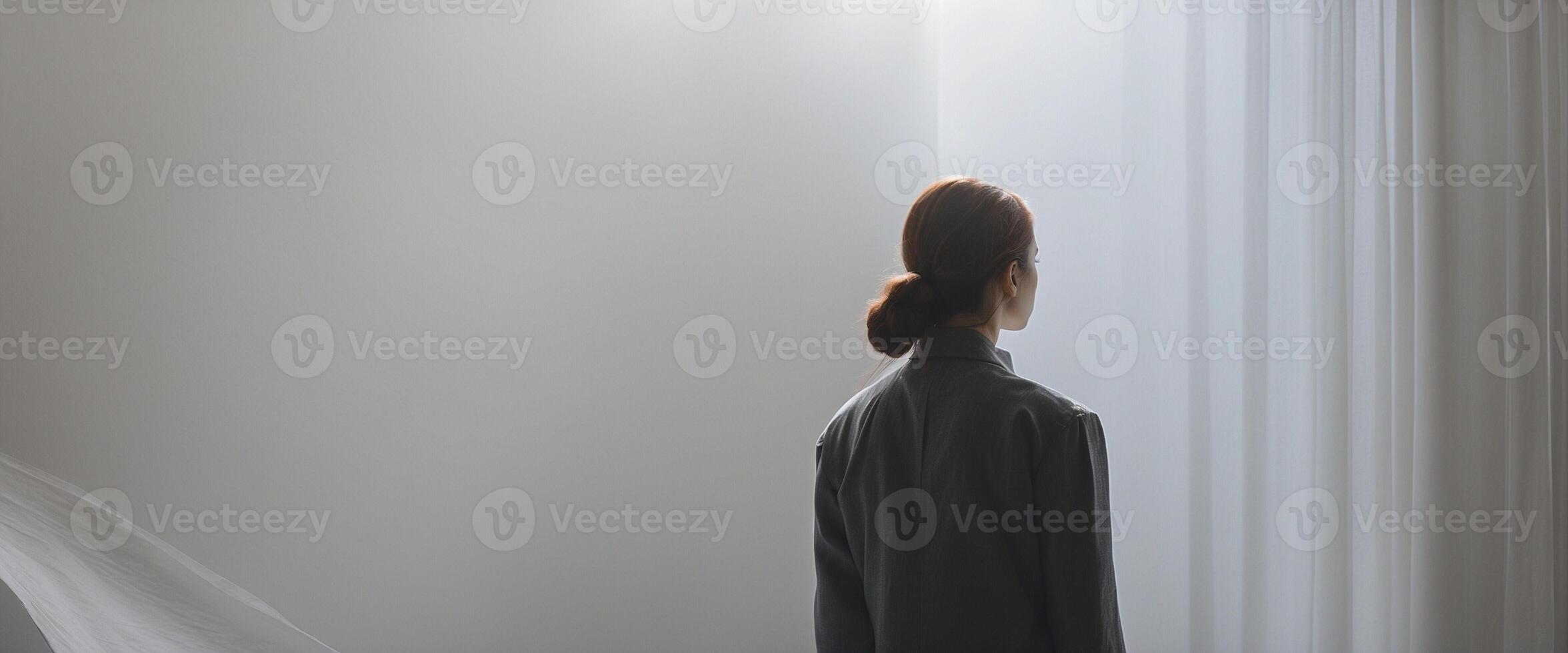 A woman standing in front of a window with a curtain photo
