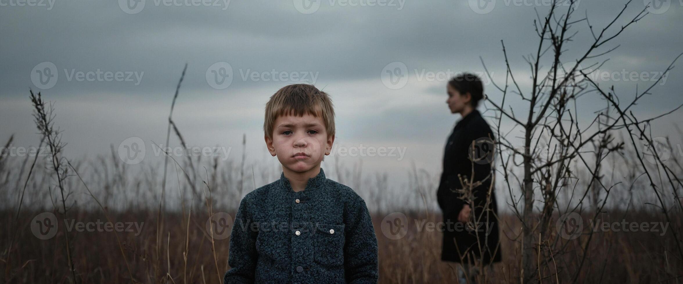 A boy and a woman standing in a field photo