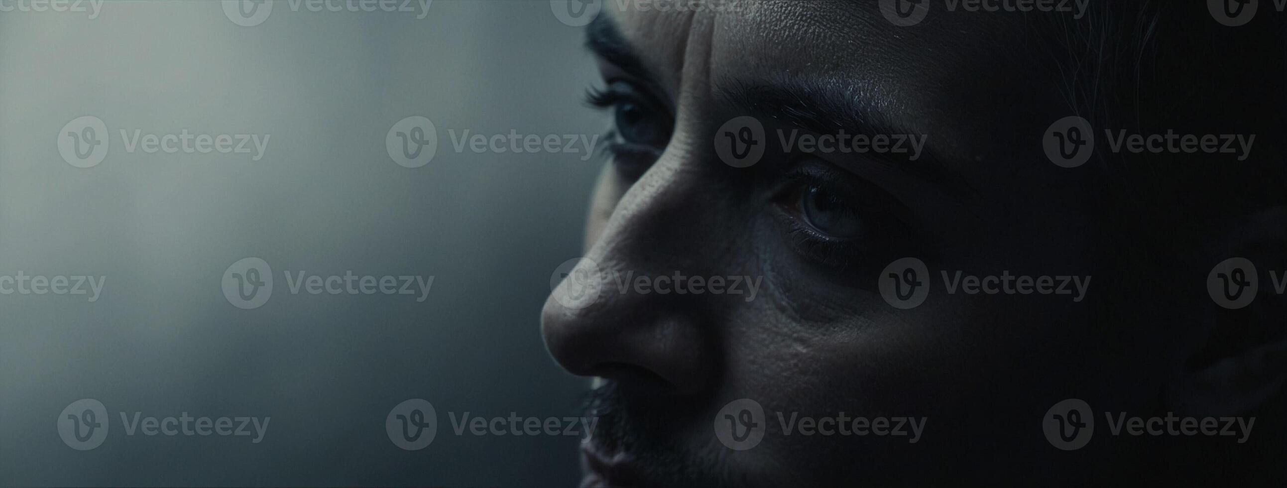 A man with a beard looks away from the camera photo