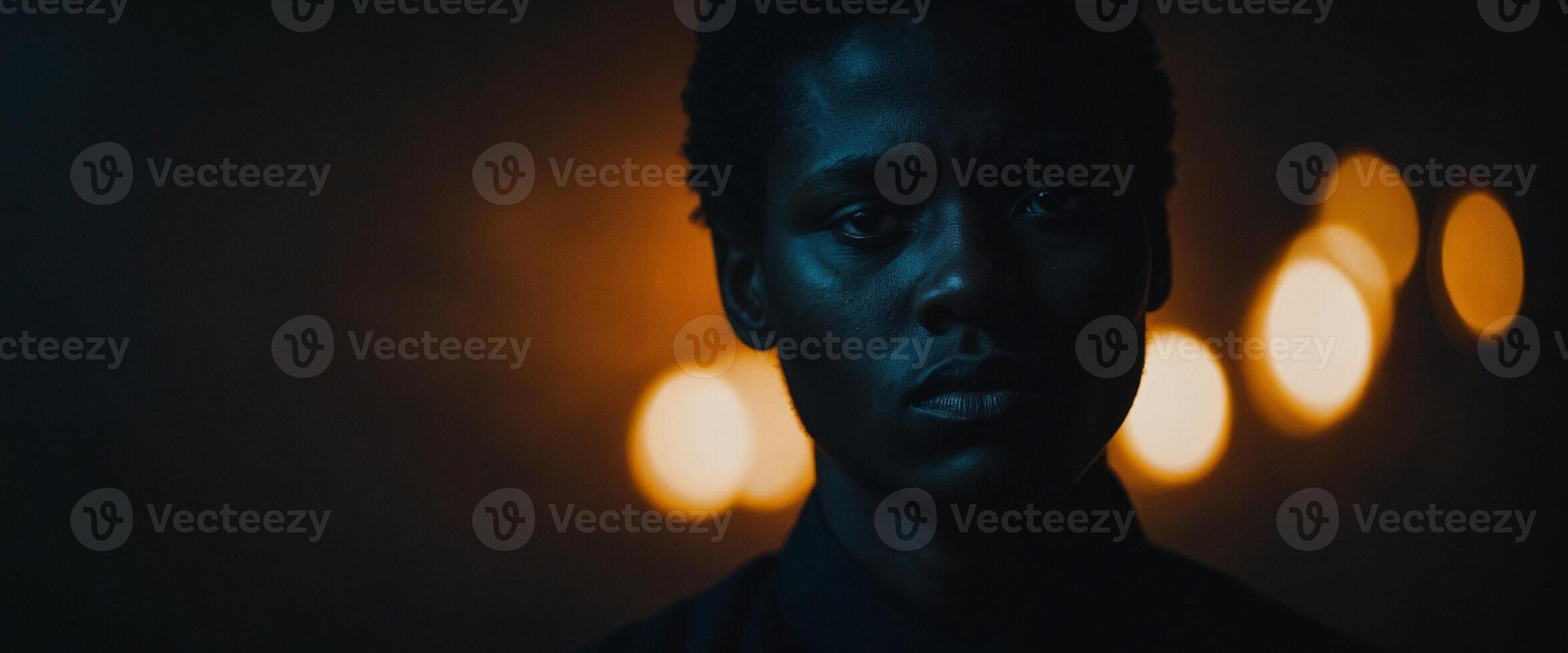 A man in the dark with lights behind him photo