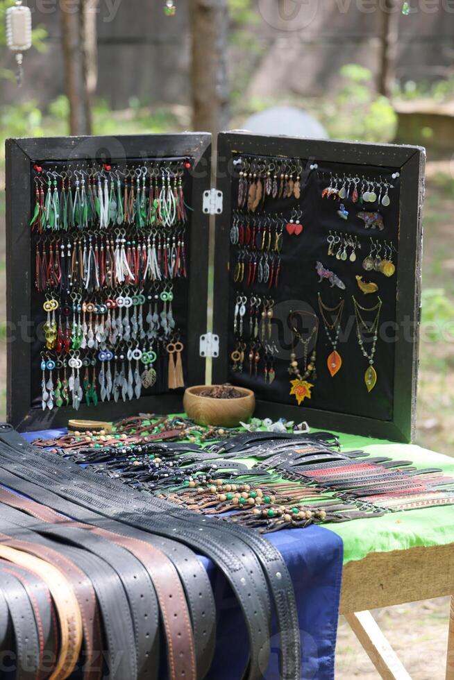 A Beautiful Array of Colorful Handmade Jewelry and Belts Displayed Outdoors for All photo