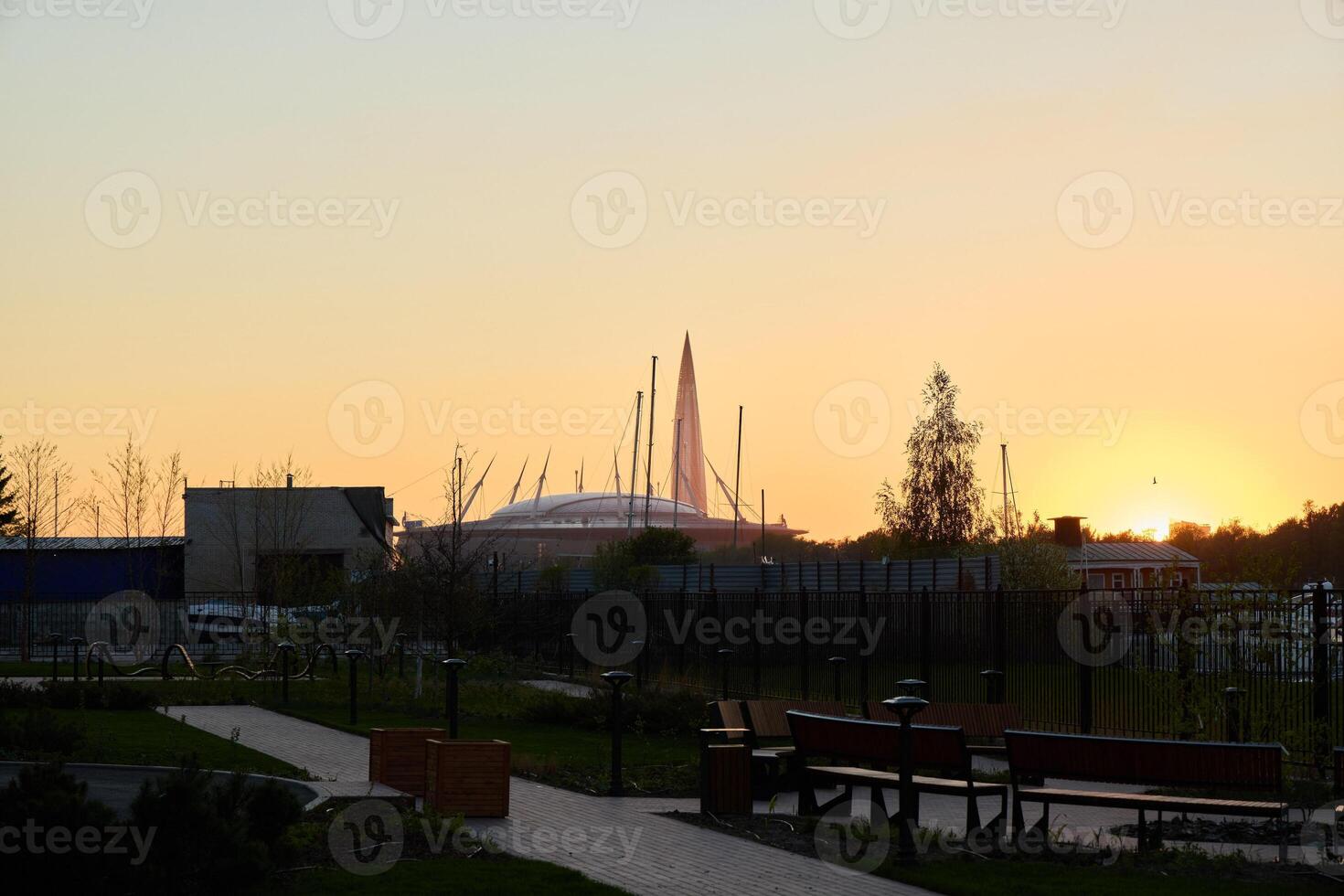 A breathtaking view of a sunset over an urban park surrounded by elegant modern architecture photo