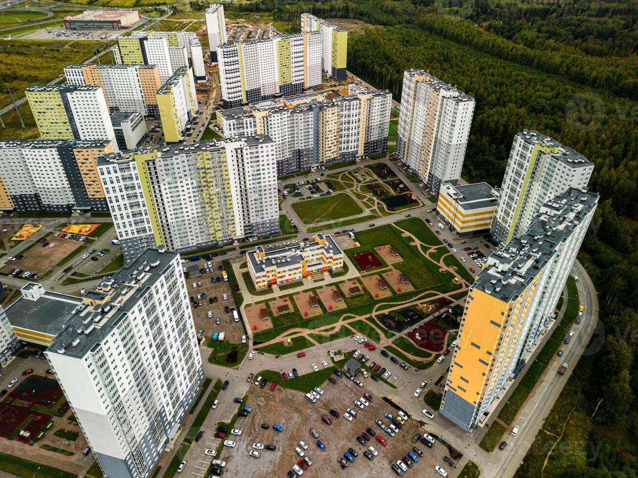 This is an Aerial View of a Modern Residential Complex, which is Surrounded by Lush Greenery photo