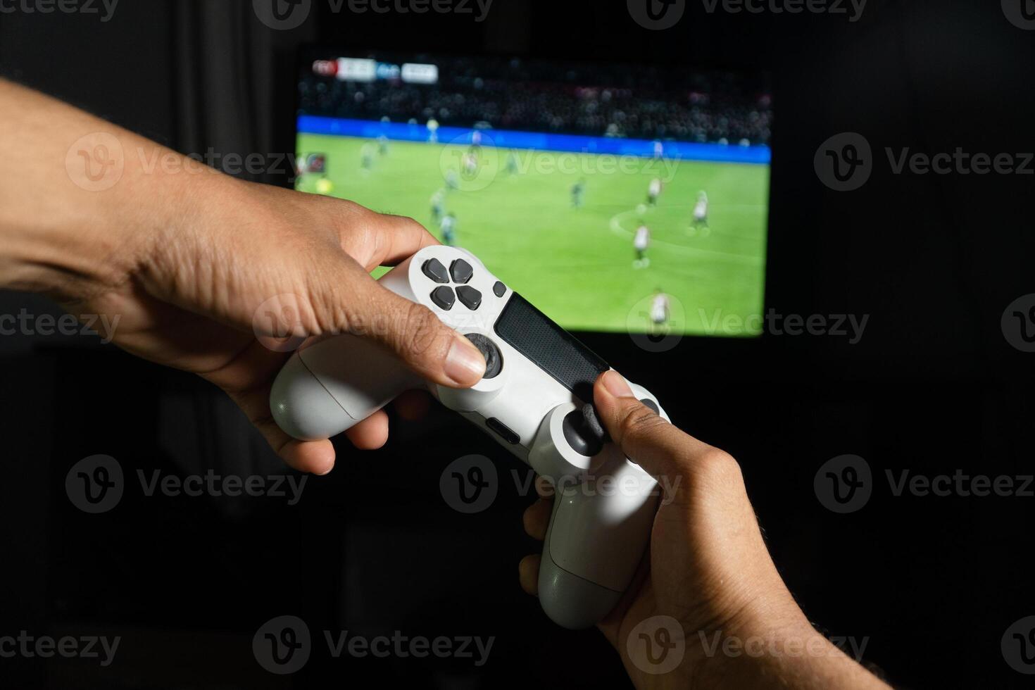 Gamer playing soccer game with a wireless controller photo