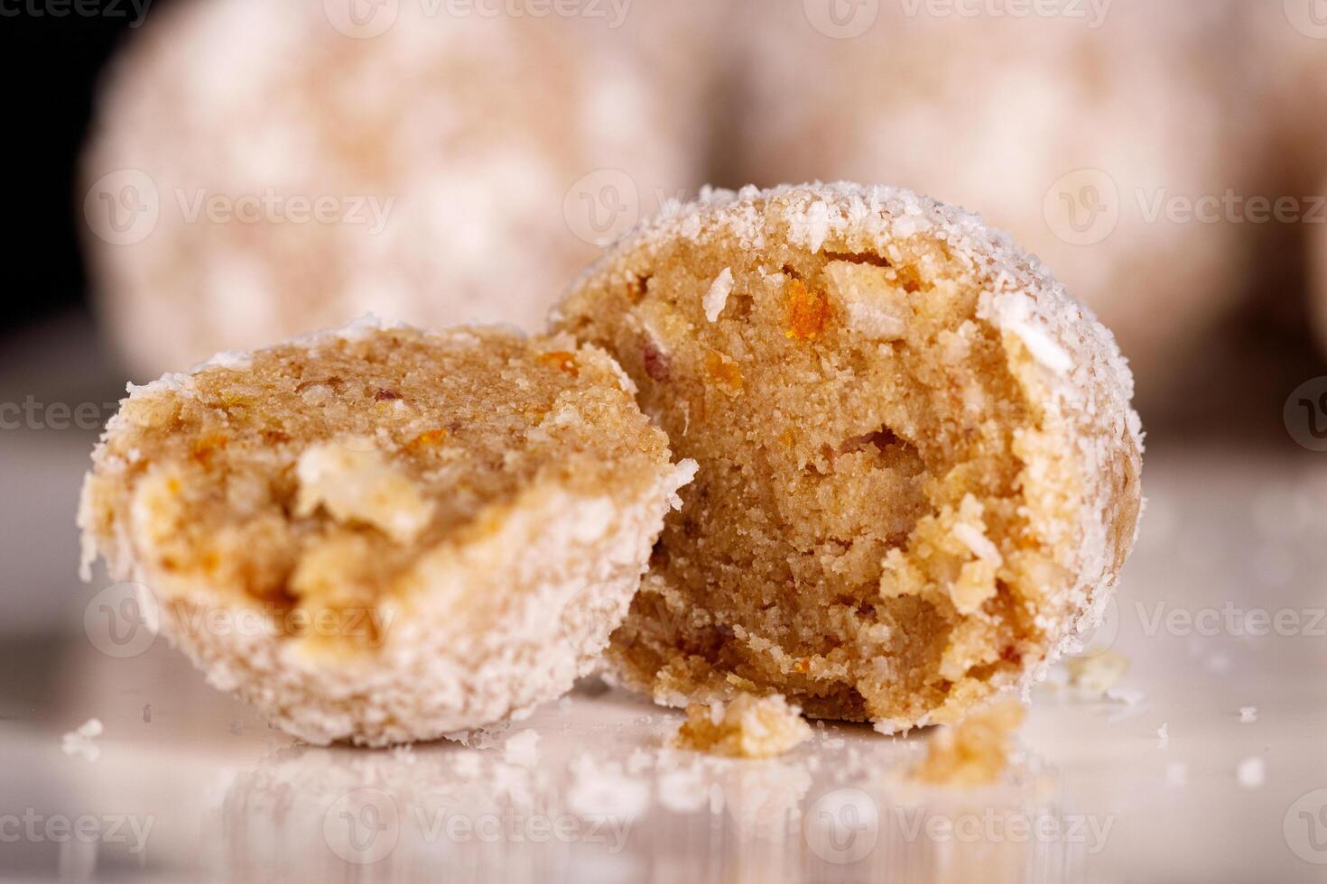 Beautiful sweets with coconut on a white plate on a black background photo