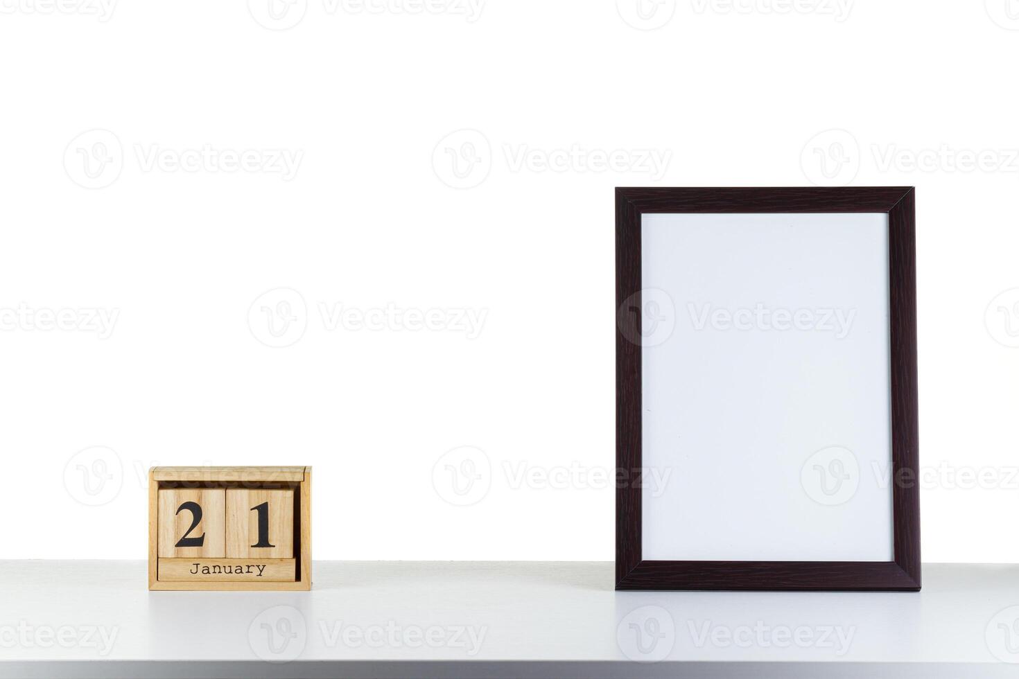 Wooden calendar 21 January with frame for photo on white table and background