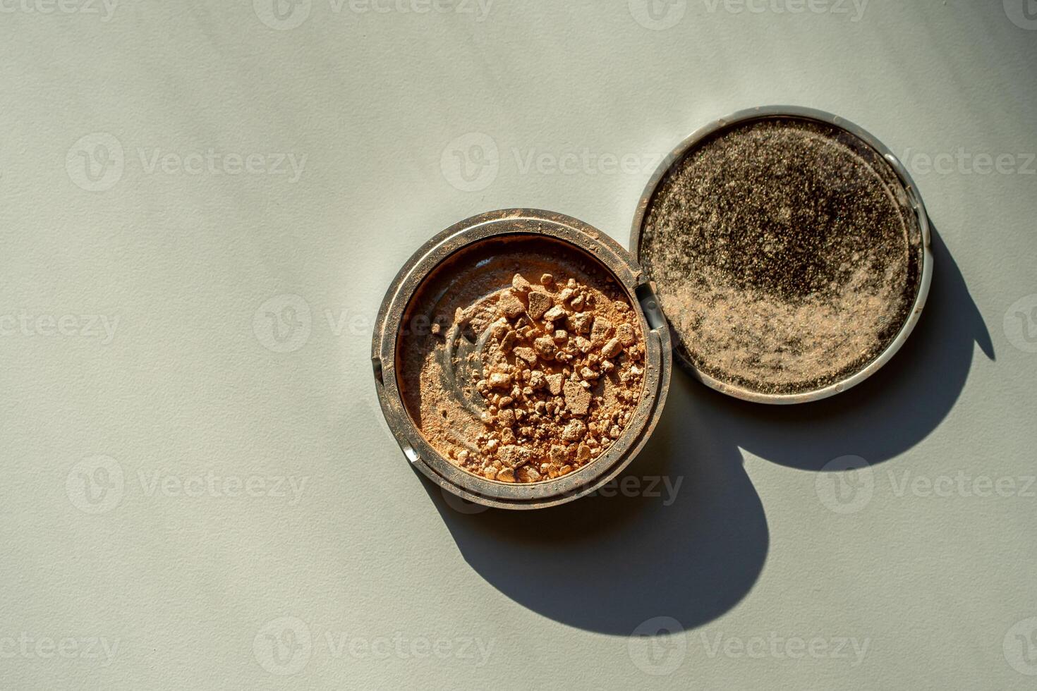 Broken palette with bronzer on a white table. Decorative cosmetics photo