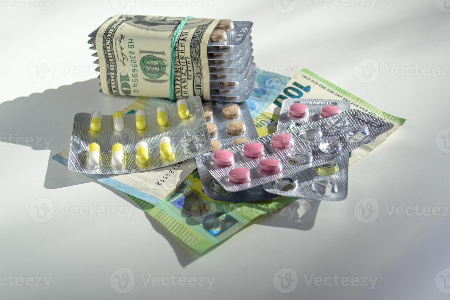Jelly capsules and hard tablets of vitamin D on dollar bills on a white table photo