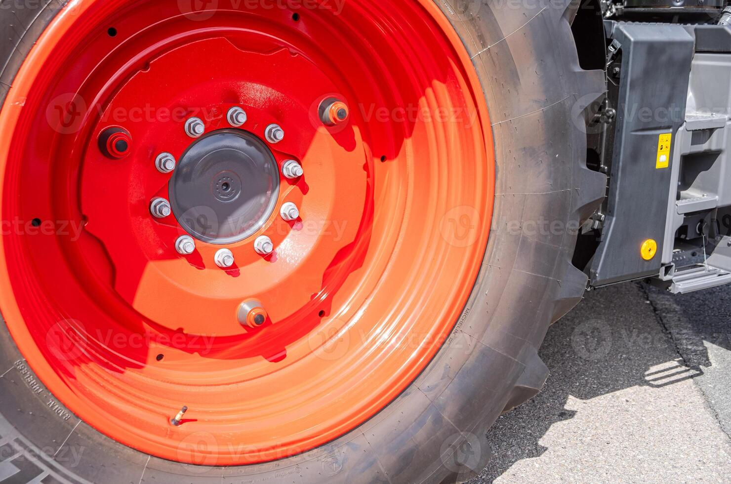 close-up view of a new tractor wheel with red rims photo