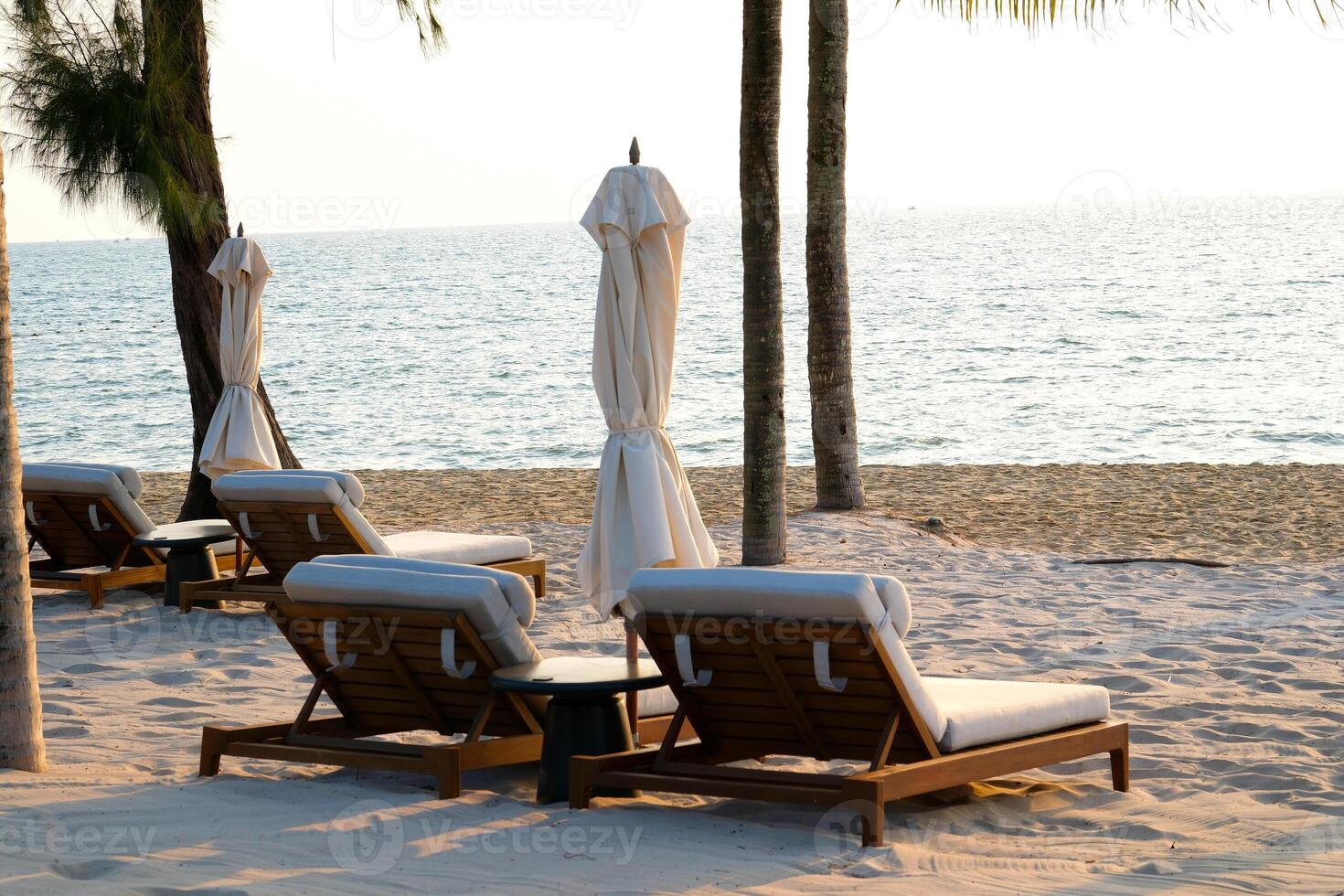 Two chaise lounges and straw umbrella on tropical beach. Coast of island Koh Rong Samloem, Cambodia. free empty copy space for text photo