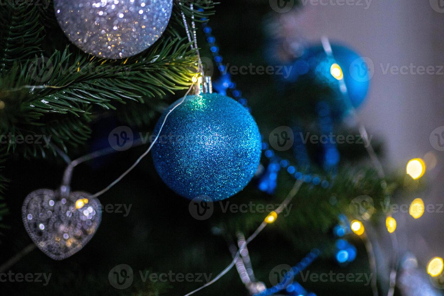Christmas decorations with blue ornaments and shimmering lights on a festive tree photo