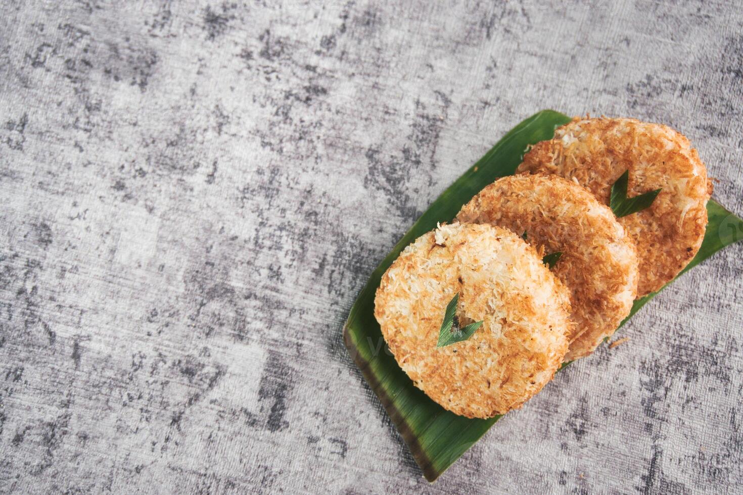 Indonesian Traditional Coconut Cake called Sagon on Banana Leaf with Rustic Background Setting photo