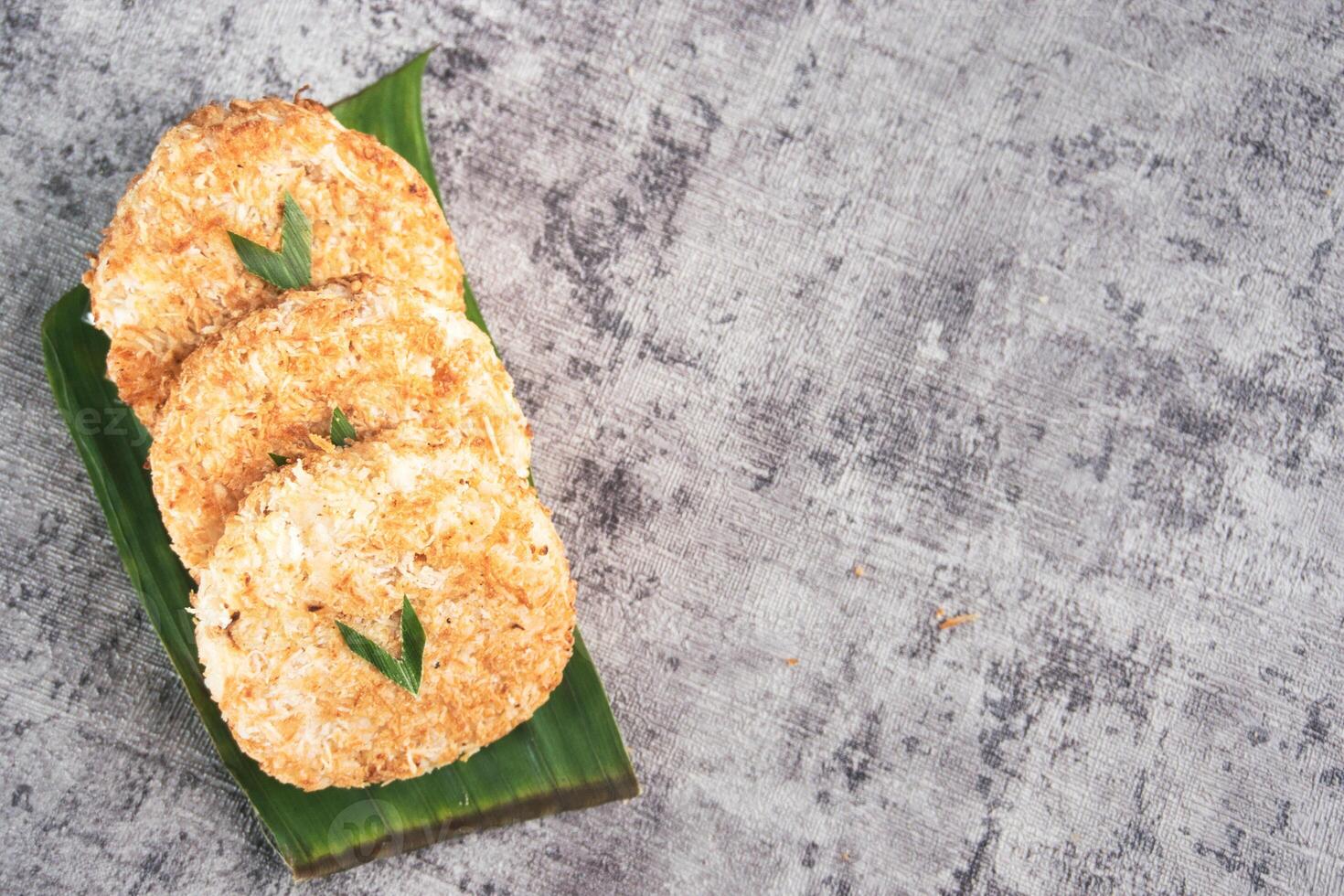 Indonesian Traditional Coconut Cake called Sagon on Banana Leaf with Rustic Background Setting photo