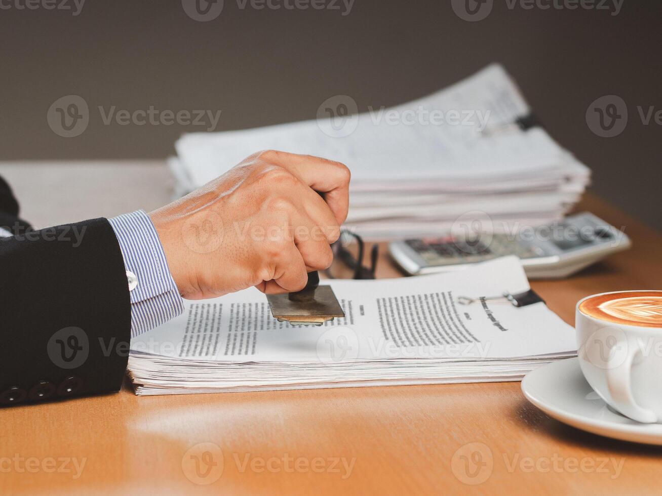 Businessman stamping approved on documents while sitting working in the office photo