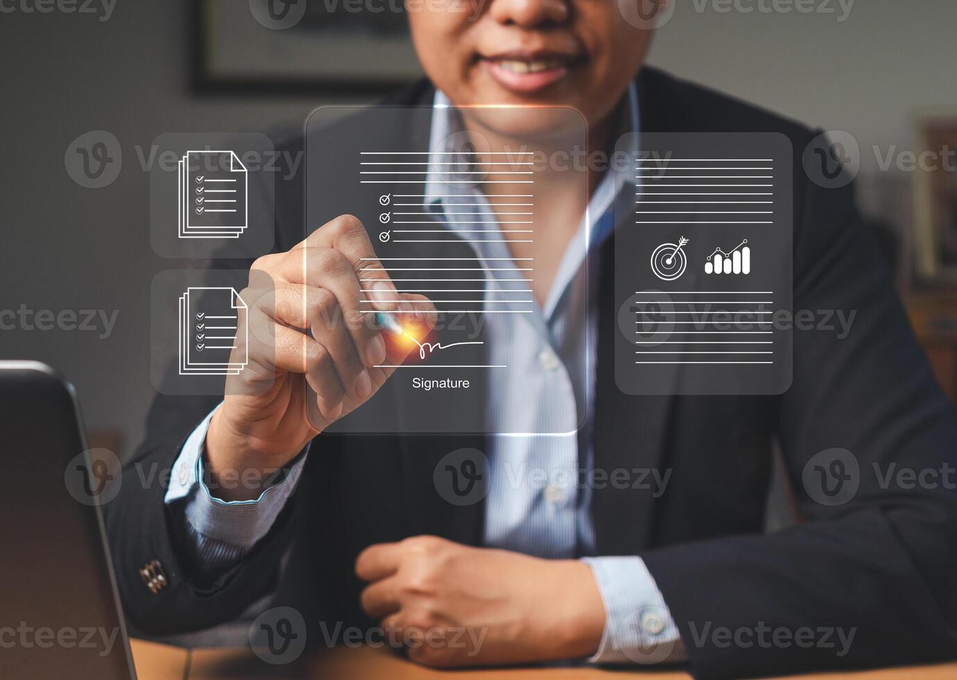 A businesswoman uses a pen to sign electronic documents on a virtual screen while sitting in the office photo