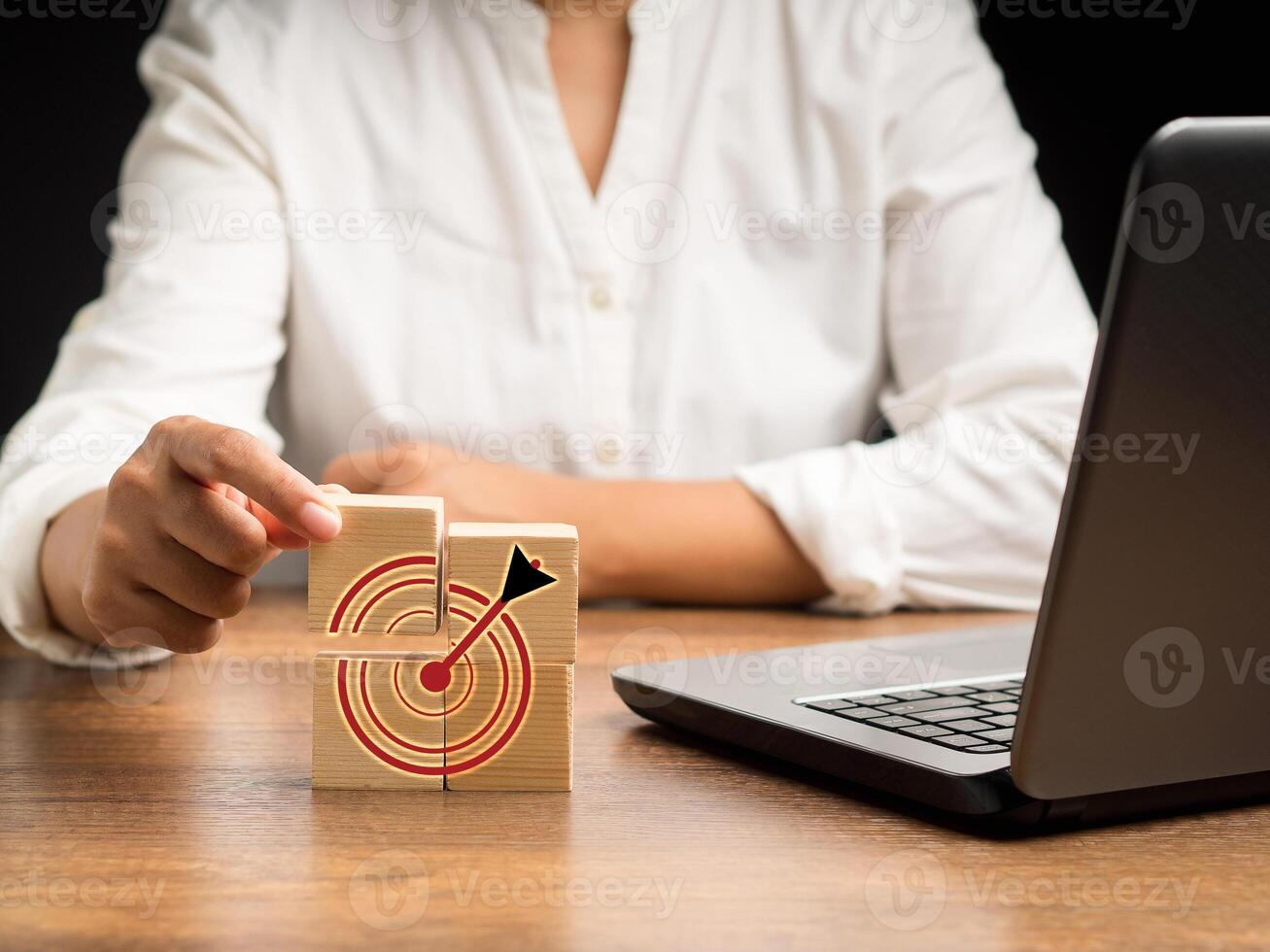 Close-up of hand businesswoman holding a wooden cube with icon business strategy while sitting in the office photo