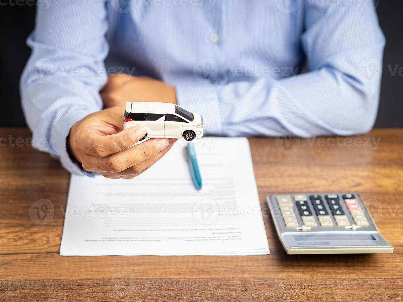 Close-up of hand holding mockup model a car while sitting in the office photo