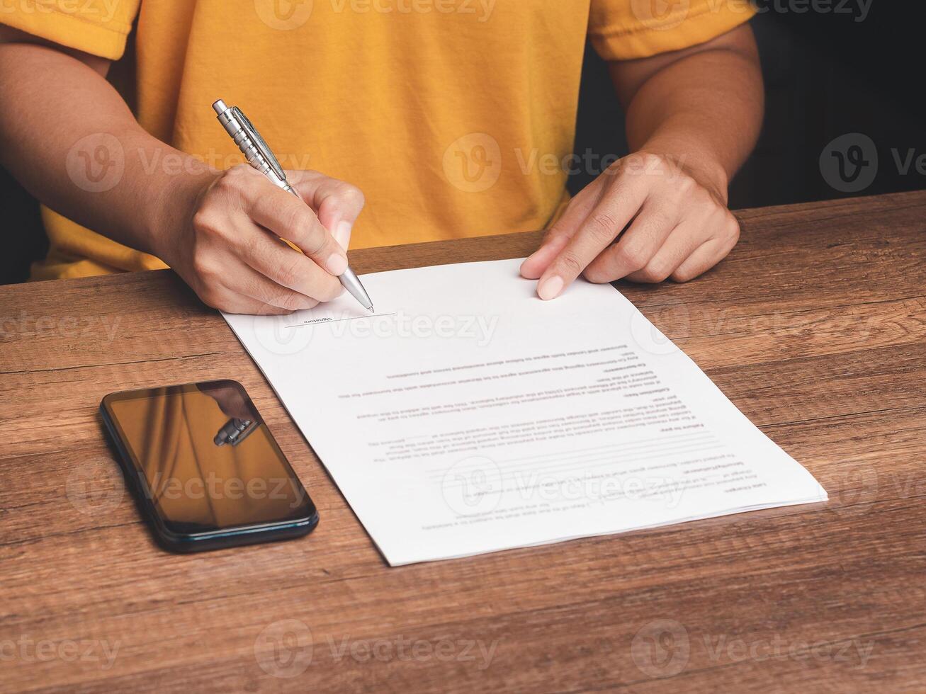 Hands of a man signing on lease contract or agreement while sitting in the office photo