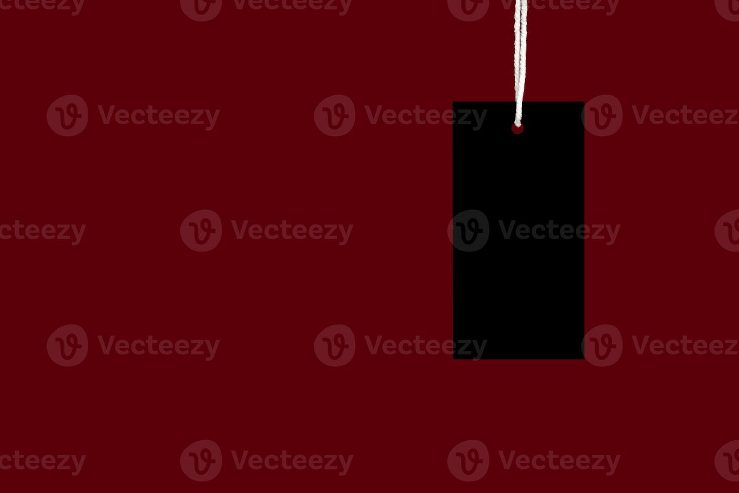 A blank black label or price tag against a red background photo