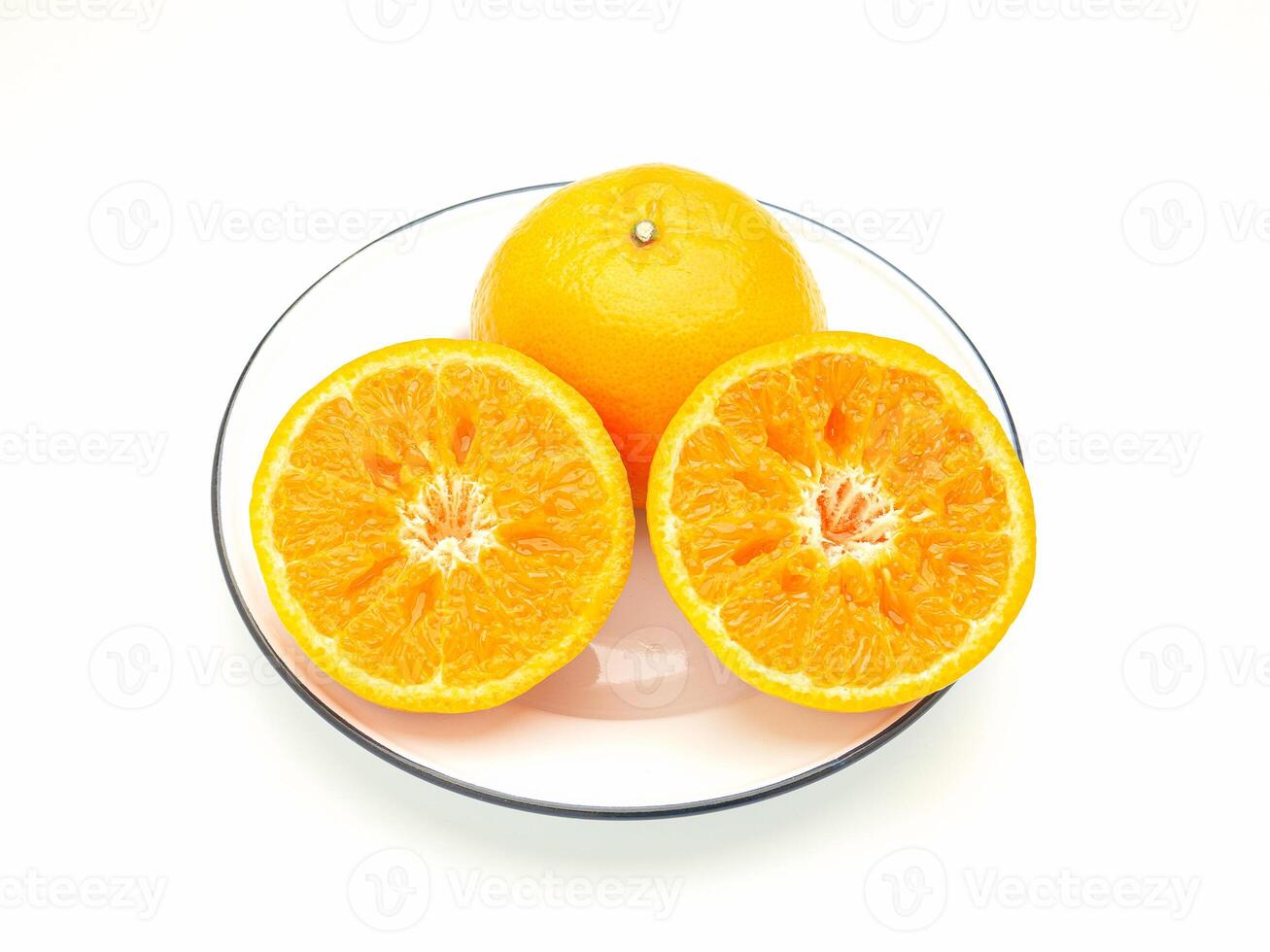 Top view of oranges cut half and whole on a white dish over a white background photo
