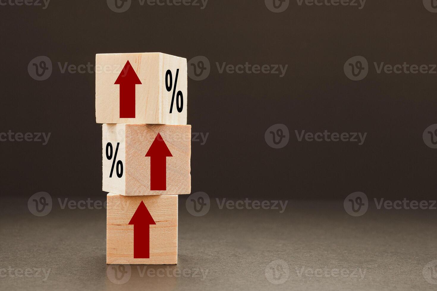 Interest rates concept. Stack of wooden cubes with arrows up and a percentage symbol with a black background photo