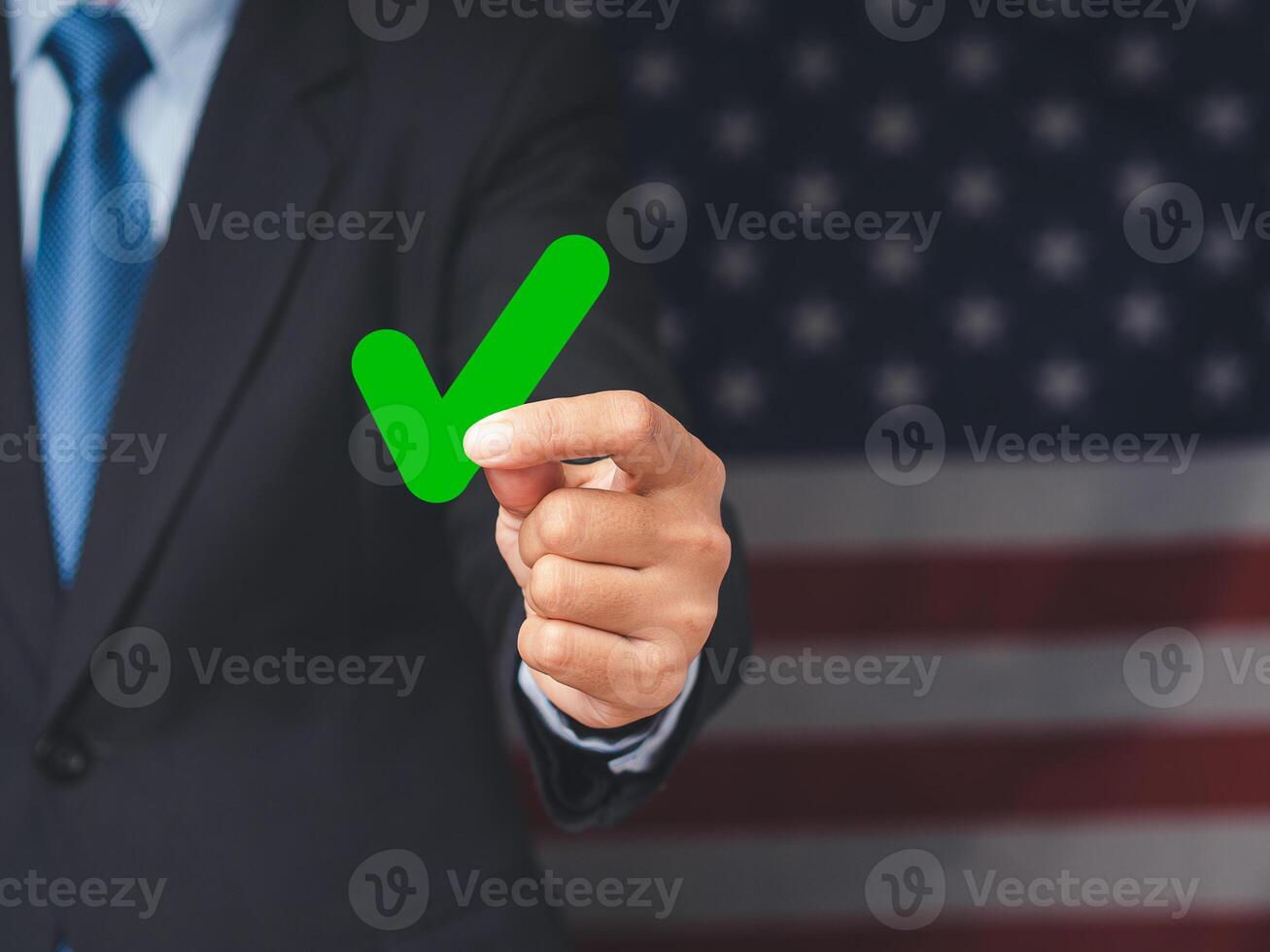Businessman holding a green check mark symbol at election while standing on the American flag background photo