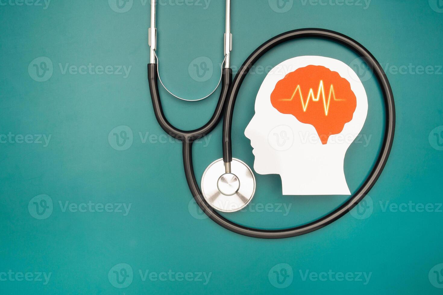A brain shape made from paper and a stethoscope on a green background photo