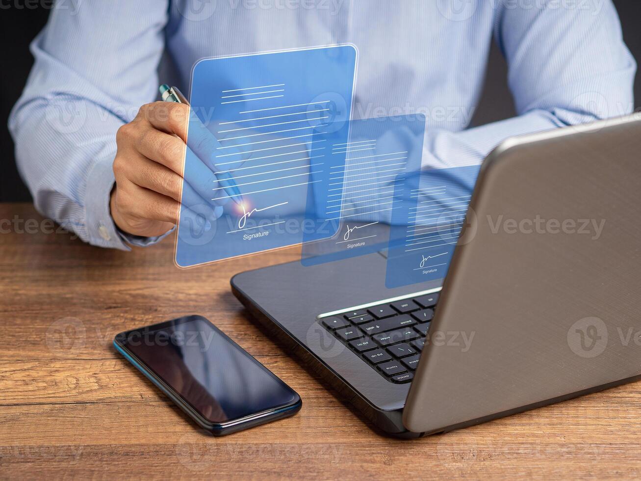 A businesswoman uses a pen to sign electronic documents on digital documents on a virtual screen photo