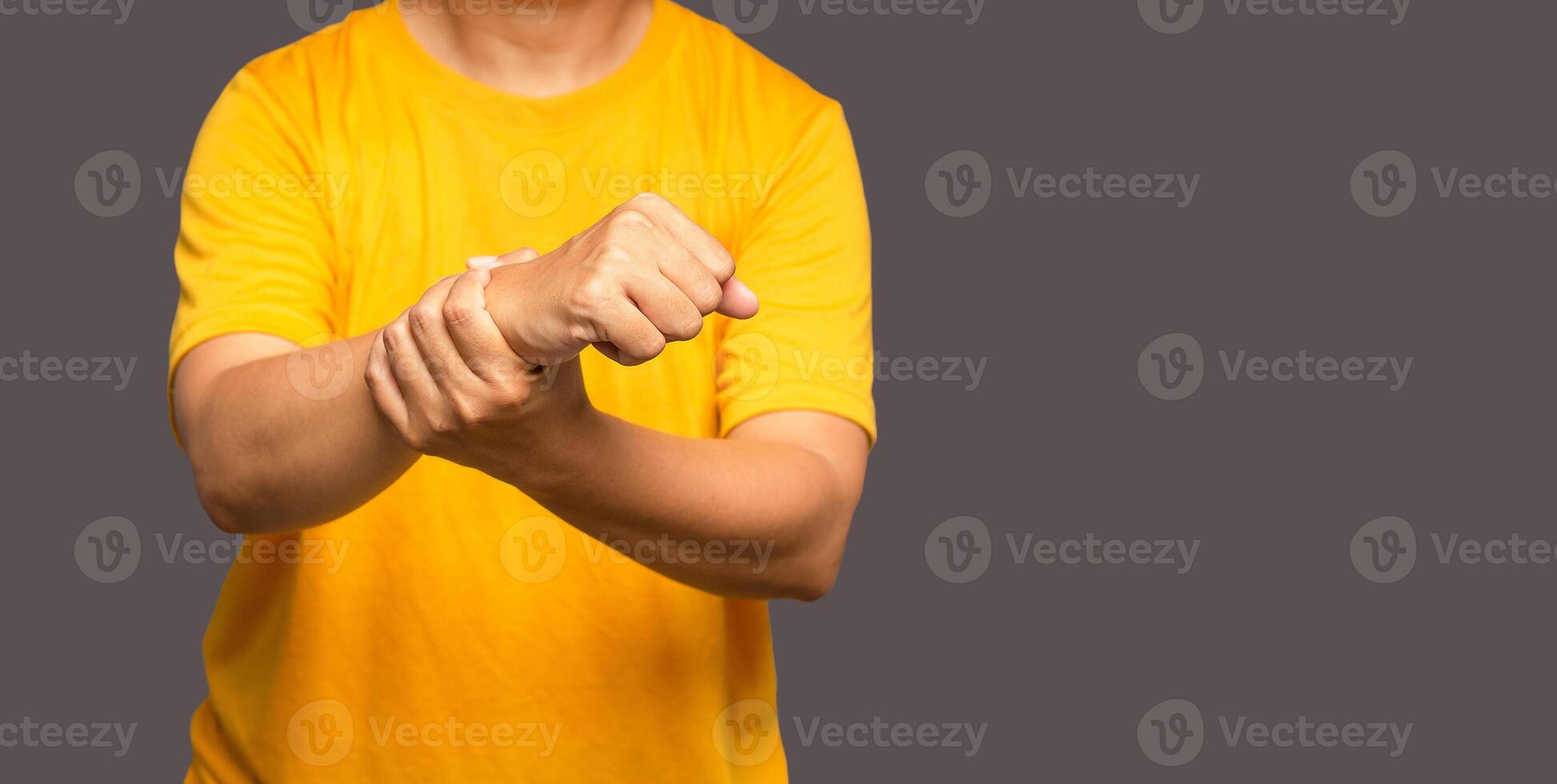 Close-up of hands male suffering from wrist pain while standing on a gray background photo