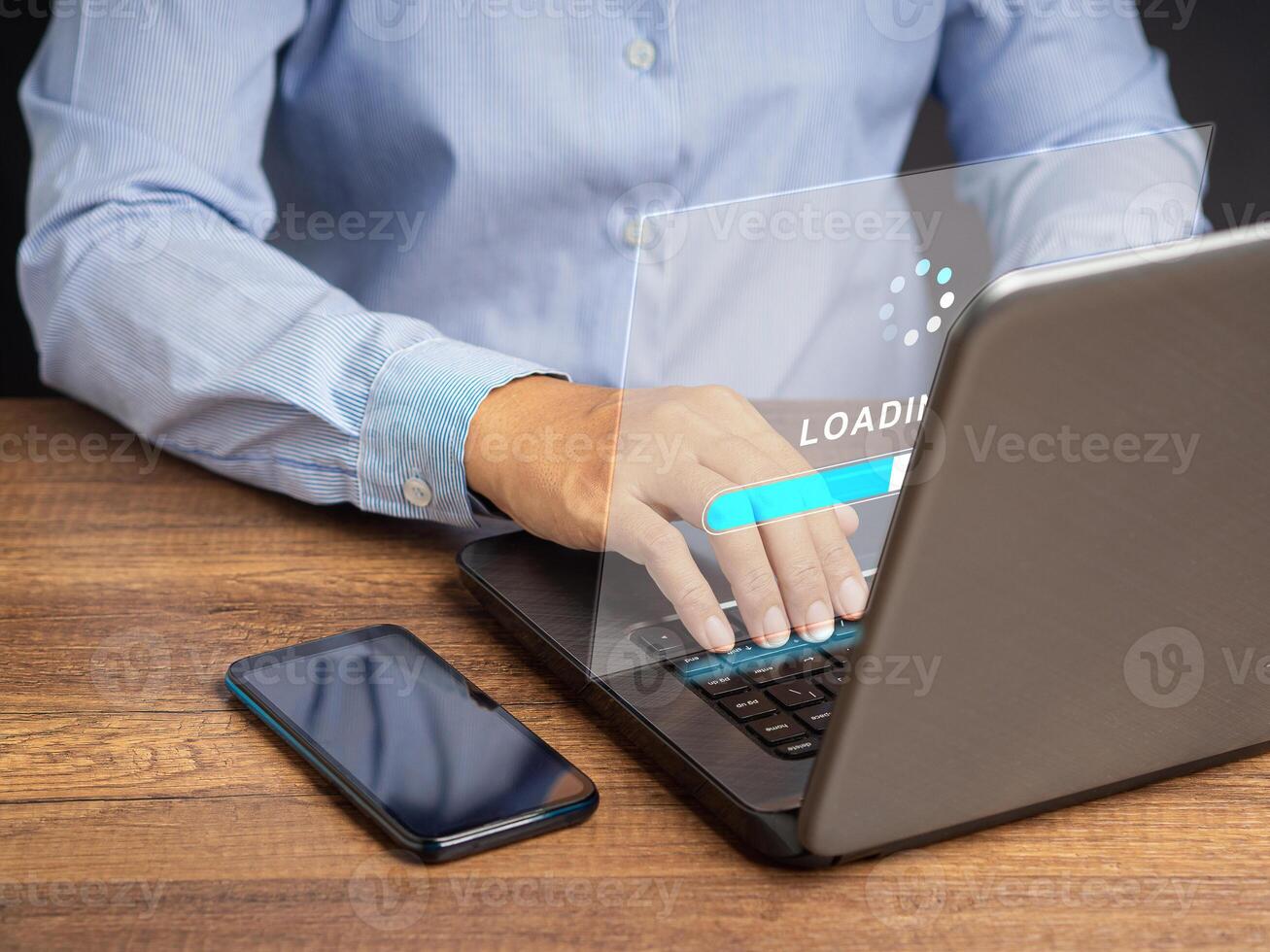 Businessman uses a laptop for loading and processing data on a virtual screen photo