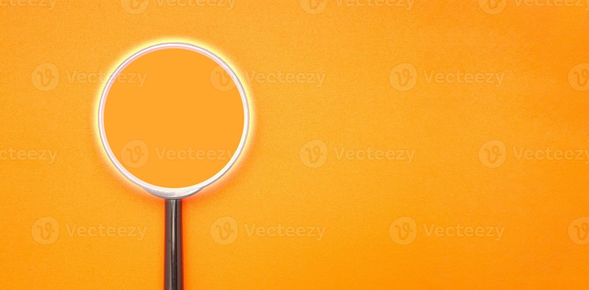 A magnifying glass on orange background. Search concept photo