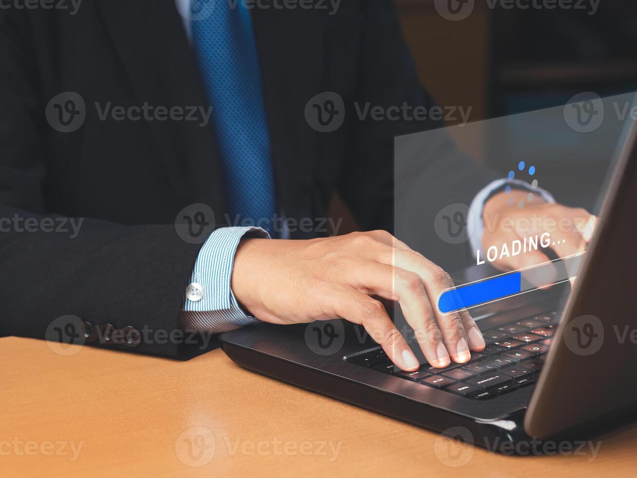 Businessman uses a laptop for loading and processing data on a virtual screen photo