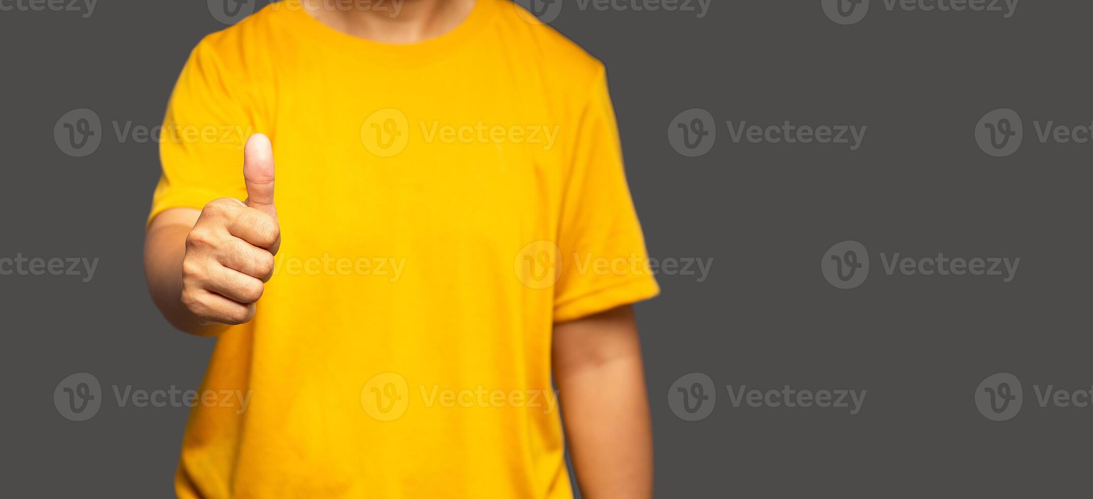 A close-up of the hand shows thumbs up while standing on gray background with copy space for text photo