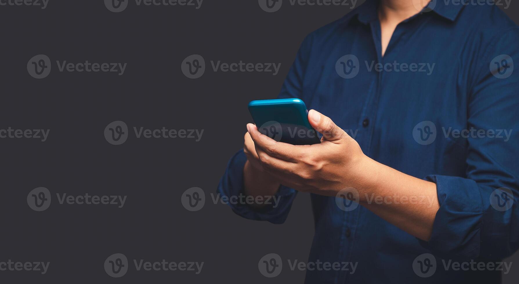 Close-up of hands businessman in a suit using a mobile phone while standing on a gray background. photo