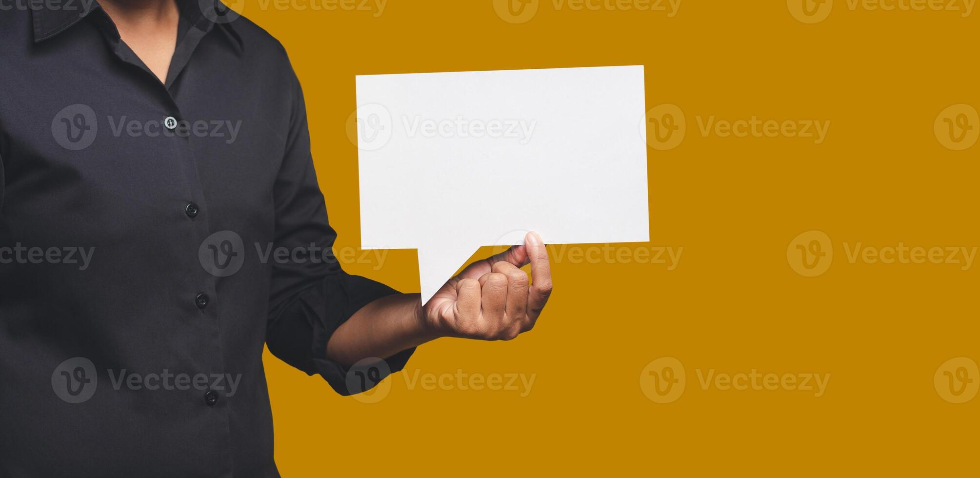 Close-up of hand businesswoman holding a blank white speech bubble while standing on an orange background photo
