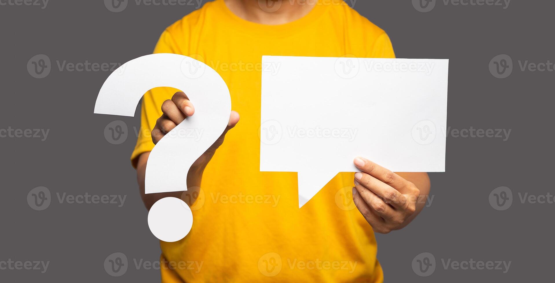 Close-up hand holding question mark symbol and a blank white speech bubble while standing on a gray background photo